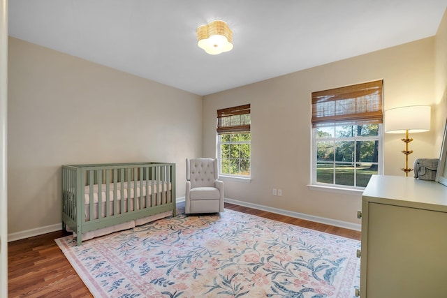 bedroom featuring wood-type flooring and a crib