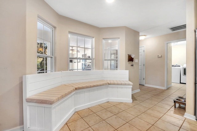 mudroom with light tile patterned floors and washing machine and dryer