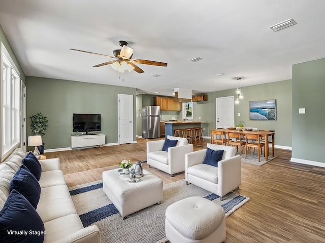 living room featuring ceiling fan, a healthy amount of sunlight, and light hardwood / wood-style floors