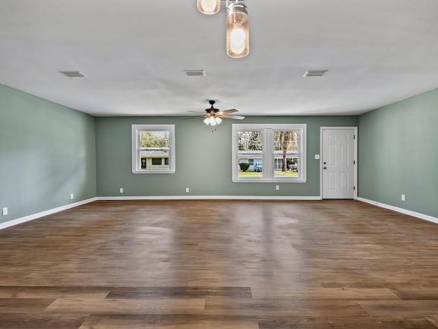 unfurnished living room featuring ceiling fan and dark hardwood / wood-style flooring