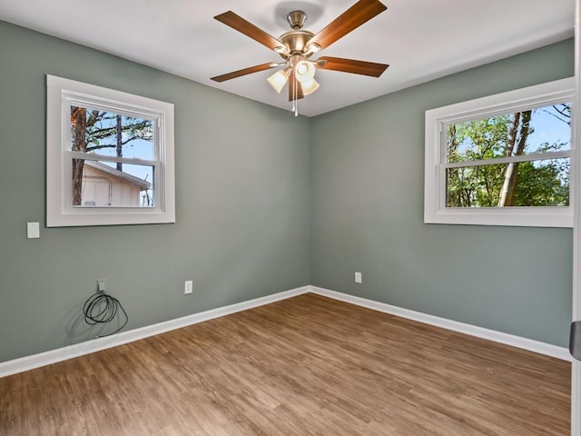 unfurnished room with ceiling fan, hardwood / wood-style floors, and a wealth of natural light