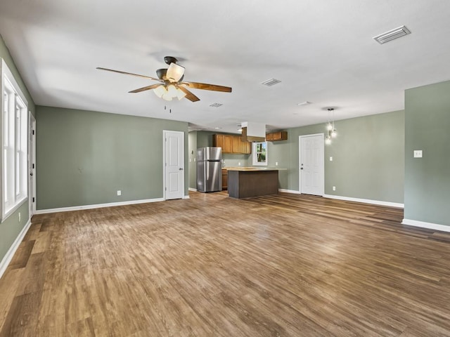 unfurnished living room with dark hardwood / wood-style flooring and ceiling fan