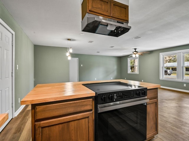 kitchen with pendant lighting, black range with electric cooktop, wood counters, and dark hardwood / wood-style floors