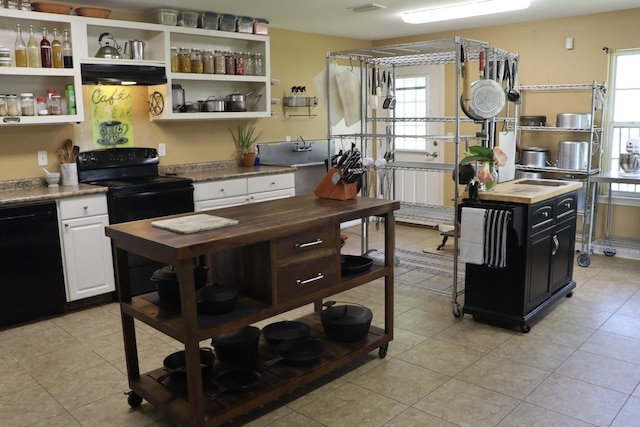 kitchen with black appliances, white cabinets, a wealth of natural light, and wood counters