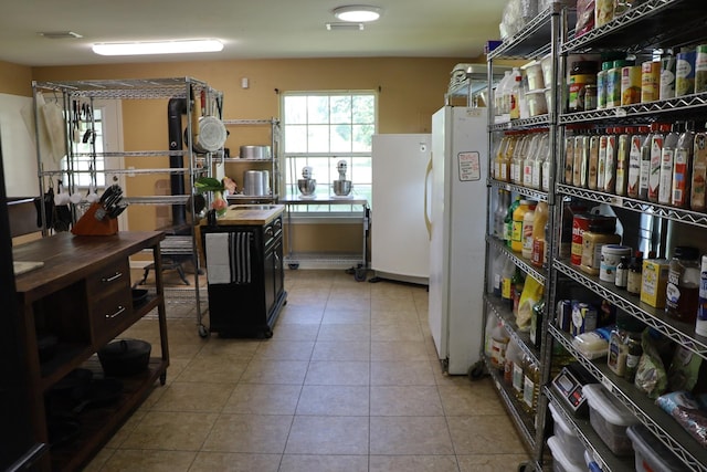 kitchen with light tile patterned flooring and white refrigerator