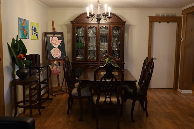 dining room featuring dark hardwood / wood-style flooring, a textured ceiling, crown molding, and an inviting chandelier