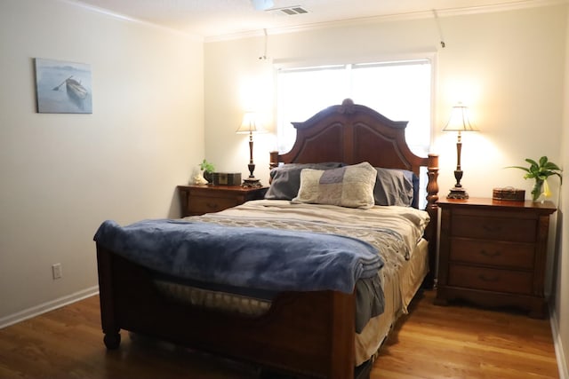 bedroom with hardwood / wood-style flooring and crown molding