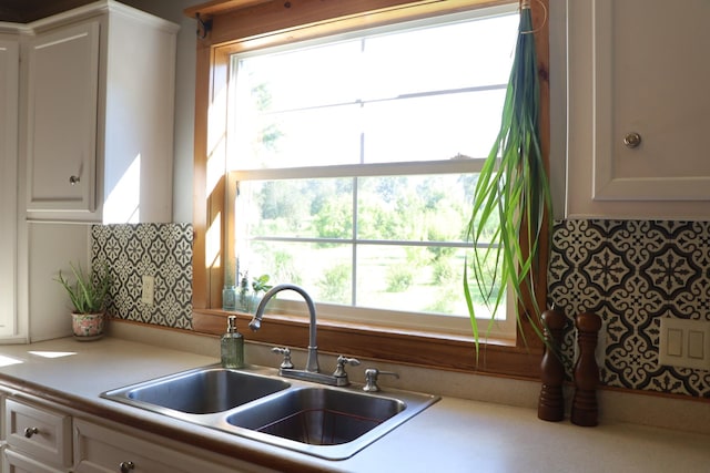 kitchen featuring white cabinets, decorative backsplash, and sink