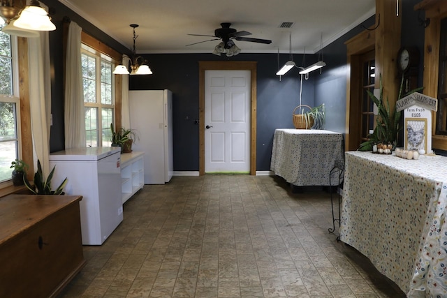 kitchen featuring white refrigerator, crown molding, white cabinetry, fridge, and decorative light fixtures