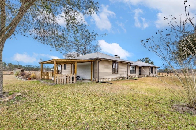 rear view of property with a garage and a lawn