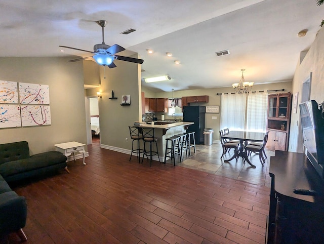 living room featuring lofted ceiling and ceiling fan with notable chandelier