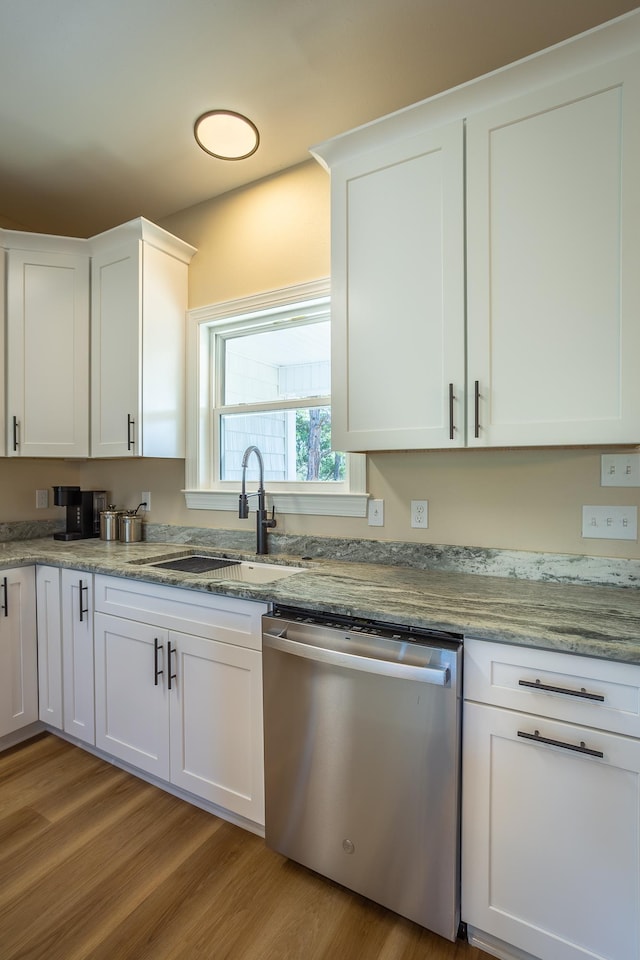 kitchen featuring sink, stainless steel dishwasher, white cabinets, and light wood-type flooring