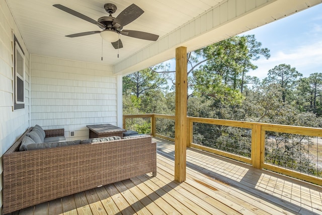 wooden deck with outdoor lounge area and ceiling fan