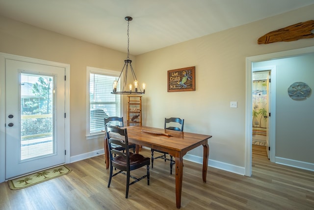 dining room with hardwood / wood-style floors and a notable chandelier