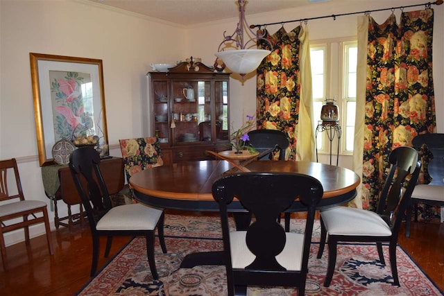 dining area featuring wood-type flooring and ornamental molding