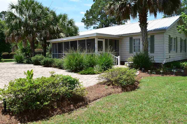 view of front facade with a front yard and a sunroom