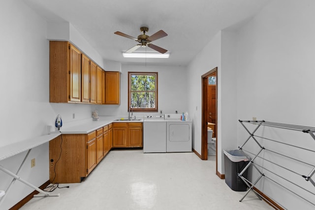 laundry area with washing machine and dryer, cabinets, sink, and ceiling fan