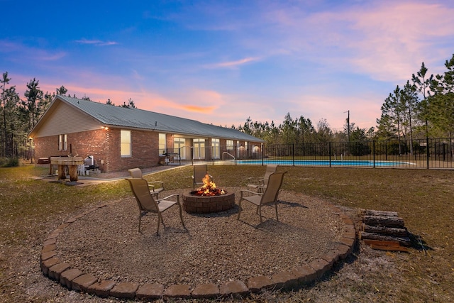 exterior space featuring a fire pit, a fenced in pool, and a patio area