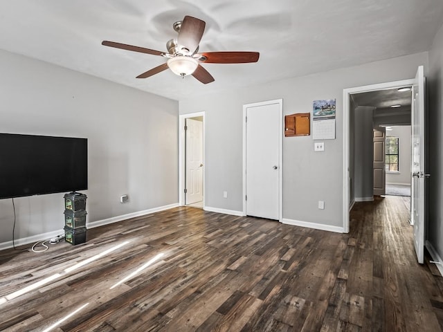 unfurnished living room featuring ceiling fan and dark hardwood / wood-style flooring