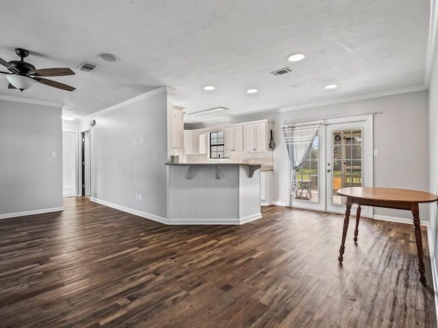 unfurnished living room featuring a barn door, crown molding, dark hardwood / wood-style flooring, and ceiling fan