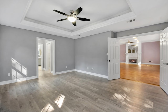 spare room with a raised ceiling, ceiling fan, and hardwood / wood-style floors