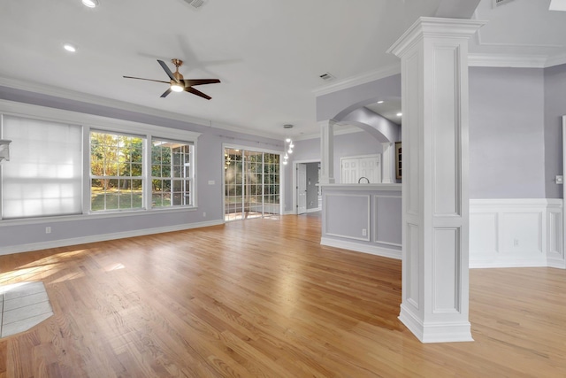 unfurnished living room featuring ornate columns, ceiling fan, crown molding, and light hardwood / wood-style flooring