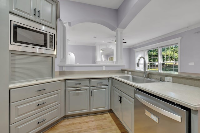 kitchen featuring gray cabinets, stainless steel appliances, kitchen peninsula, ceiling fan, and sink