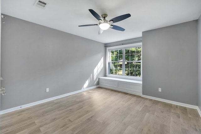 empty room with ceiling fan and light hardwood / wood-style floors