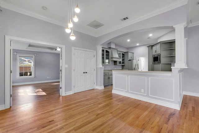 kitchen with crown molding, light wood-type flooring, gray cabinetry, and appliances with stainless steel finishes