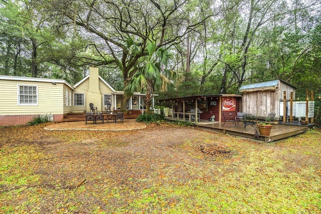 3206 Old Bainbridge Rd, Tallahassee, FL 32303 - rear view of property with a wooden deck and a chimney