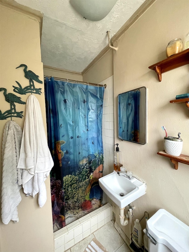 bathroom with tile patterned floors, sink, crown molding, a textured ceiling, and curtained shower