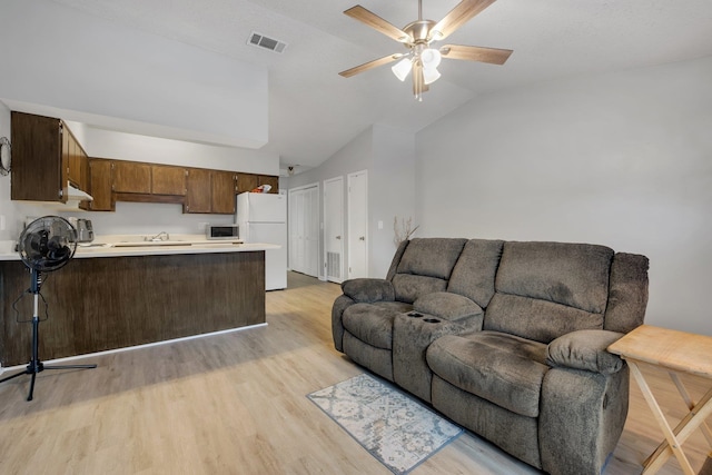 living room featuring light hardwood / wood-style flooring, ceiling fan, sink, and vaulted ceiling