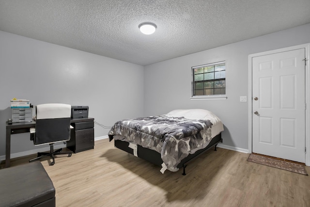 bedroom with hardwood / wood-style floors and a textured ceiling