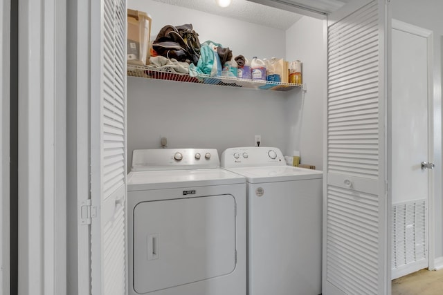 laundry area featuring separate washer and dryer and a textured ceiling