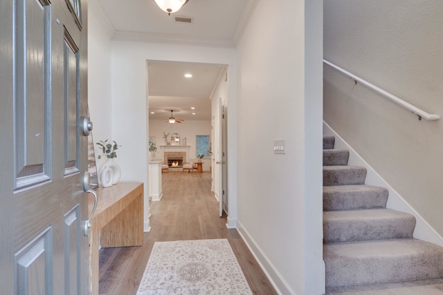 3283 Gramercy Pl, Tallahassee, FL 32308 - entrance foyer with wood finished floors, stairs, a lit fireplace, ornamental molding, and recessed lighting