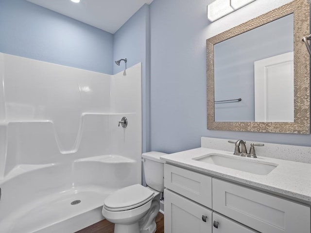 bathroom featuring hardwood / wood-style flooring, toilet, vanity, and walk in shower