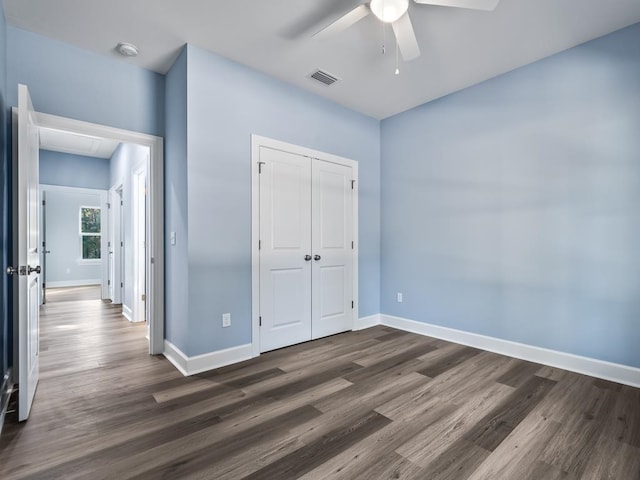 unfurnished bedroom with ceiling fan, dark hardwood / wood-style floors, and a closet