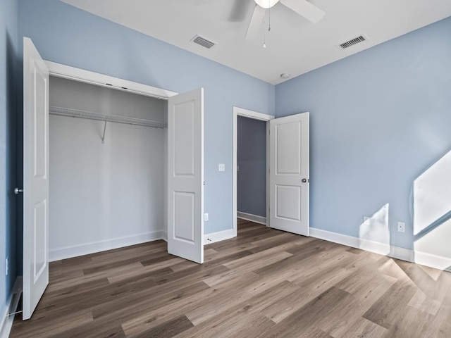 unfurnished bedroom featuring hardwood / wood-style floors, ceiling fan, and a closet