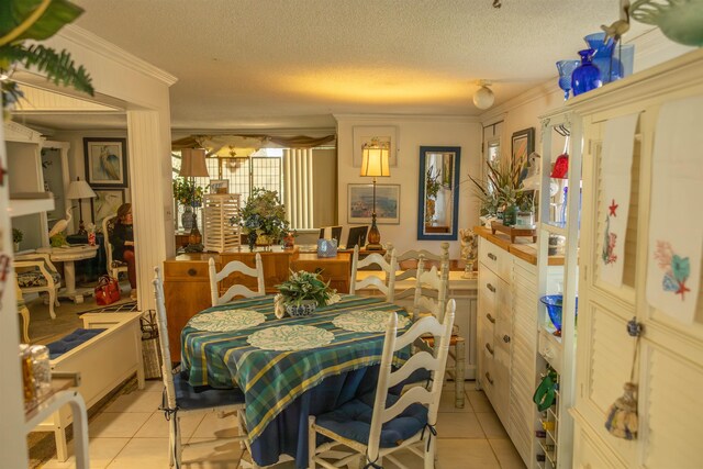 tiled dining space featuring a textured ceiling and ornamental molding