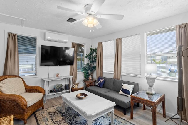1405 SE 2nd Ave, Steinhatchee, FL 32359 - living area featuring a wall mounted air conditioner, light wood-type flooring, healthy amount of natural light, ceiling fan, and a textured ceiling