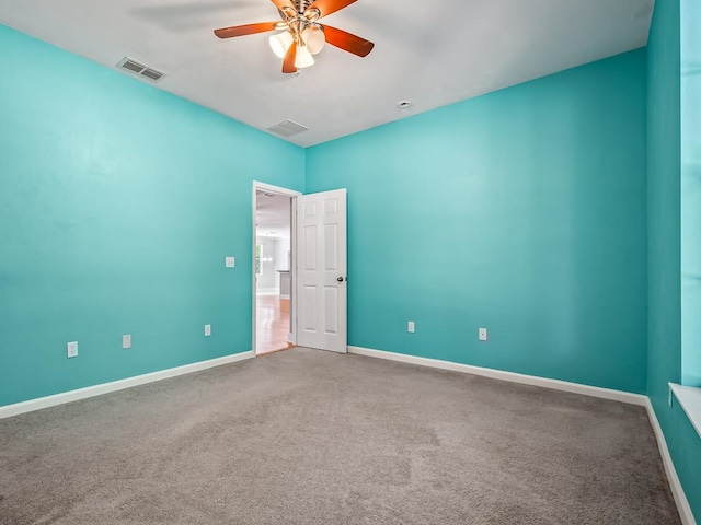 carpeted spare room featuring ceiling fan