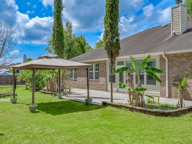 rear view of house featuring a lawn, a patio, and a gazebo