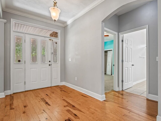 foyer featuring ornamental molding and light wood-type flooring