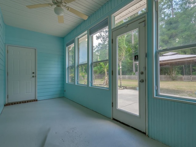 unfurnished sunroom featuring ceiling fan