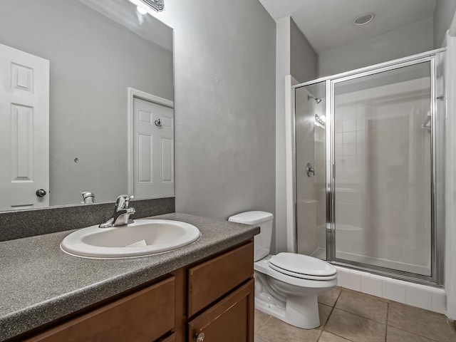 bathroom featuring vanity, a shower with shower door, tile patterned flooring, and toilet