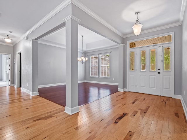 foyer entrance featuring an inviting chandelier, light wood-type flooring, and ornamental molding