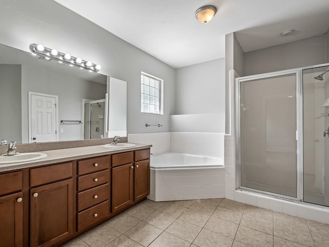 bathroom featuring plus walk in shower, vanity, and tile patterned floors