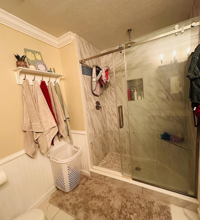 bathroom with tile patterned flooring, an enclosed shower, and ornamental molding