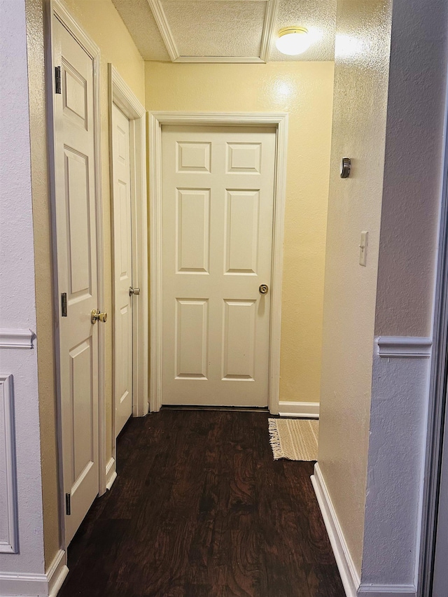 hallway featuring dark hardwood / wood-style floors and a textured ceiling