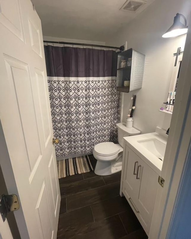 bathroom with toilet, vanity, and a shower with shower curtain